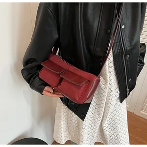 Detail view of burgundy faux suede baguette bag showing the double front flap pockets