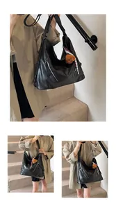 Detailed view of black faux leather tote bag featuring metal zippers and bear charm