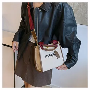 Τσάντα tote από καμβά και δέρμα με λουράκι ώμου σε μοντέλο για προβολή μεγέθους