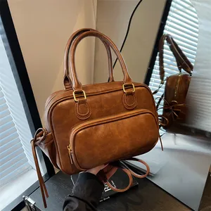 Vintage dark brown PU leather handbag with front pocket and decorative side tassels