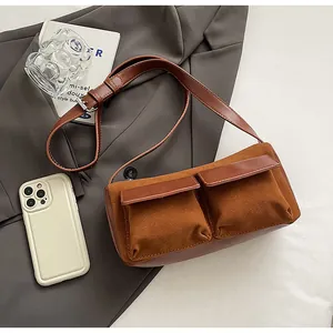 Detailed overhead view of vintage brown suede baguette bag with dual cargo pockets and strap