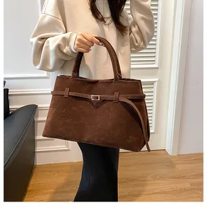 Close-up of vintage dark brown frosted leather tote with metallic buckle and twin handles