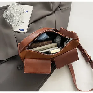 Interior storage capacity of the brown suede baguette bag with daily essentials shown