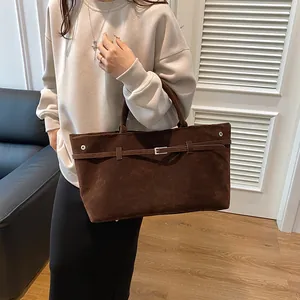Retro dark brown matte leather tote bag with silver buckle worn by a female model