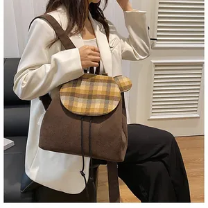 Detail eines dunkelbraunen Cord-Rucksacks mit Karo-Klappe und niedlichen Bärenohren