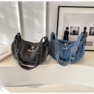 Detail of retro washed denim hobo bags in blue and dark grey with adjustable straps