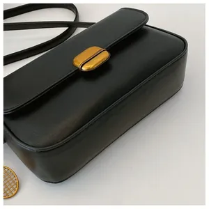 Détail du sac bandoulière noir en cuir avec fermoir rectangulaire doré classique
