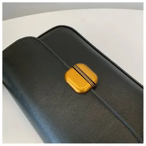 Vue détaillée du sac à main en cuir grainé noir avec une boucle métallique dorée