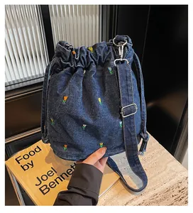 Détails de broderies tulipes sur un sac seau en denim bleu avec cordon de serrage
