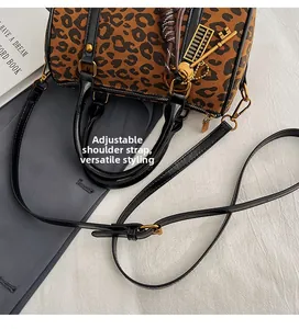 Details der Boston-Tasche mit Leopardenmuster, Goldanhängern und verstellbarem Riemen