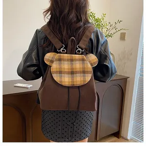 Detailansicht eines braunen Cord-Rucksacks mit süßer karierter Klappe in Bärenform