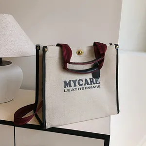 Πάνινη τσάντα tote με μινιμαλιστική στάμπα γραμμάτων και λαβές σε αντίθεση χρωμάτων