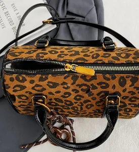 Gros plan du sac Boston léopard montrant la fermeture dorée et la texture velours