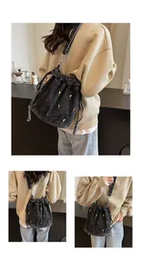Détail du sac seau en denim noir avec broderie florale et sangle ajustable