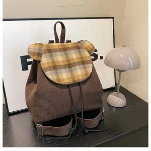Detailansicht des Cord-Rucksacks mit Bärenohr-Klappe und braunem Vintage-Karomuster