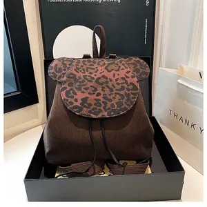 Detail eines Cord-Rucksacks mit Leopardenmuster und Kordelzug in einer Geschenkbox
