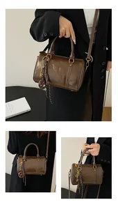 Dettaglio borsa Boston vintage marrone scuro con ciondolo chiave e nappa intrecciata