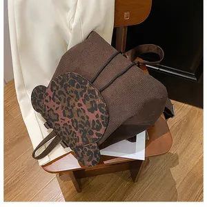 Detailansicht eines braunen Cord-Rucksacks mit einer Bären-Tasche im Leoparden-Muster