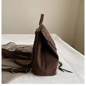 Seitenansicht des braunen Cord-Rucksacks mit Leopardenmuster und Metallschnallen