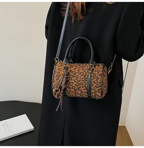 Dettaglio della borsa Boston leopardata con ciondolo a frange marroni e metallo dorato