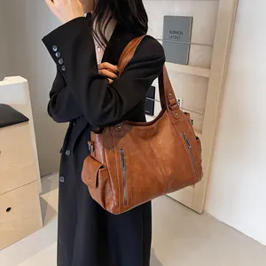 Brown leather tote bag with multi-pocket design shown on model for business commute