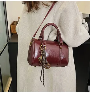 Dettaglio della pelle cerata bordeaux e ciondoli decorativi sulla borsa modello Boston