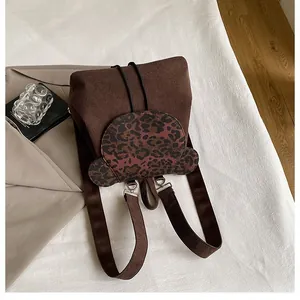 Detail eines Cord-Rucksacks mit Klappe im Leopardenmuster-Bärendesign und Silberteilen