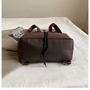 Detail des Leopard-Rucksacks mit braunem Cordsamt, Lederboden und silbernem D-Ring-Element