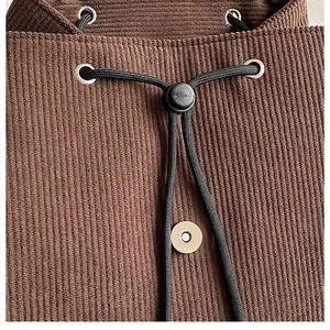 Detail der braunen Cordtasche mit schwarzem Kordelzug und silberner Magnetverschluss-Schnalle