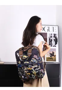Detailweergave van blauwe rugzak met Chinese landschapsprint en bruine nylon riemen