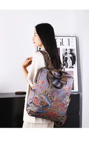 Zijaanzicht van een grijze rugzak met kraanvogel- en bloemenprint gedragen door model