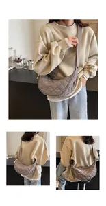 Detail of grey quilted crescent bag showing the adjustable strap and nylon texture on model