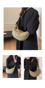 Detail of olive green quilted crescent bag showing stitching and wide strap