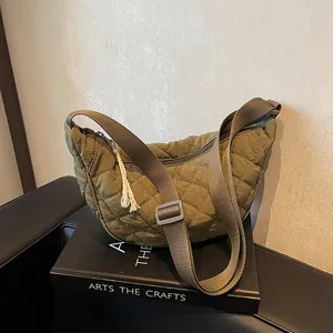 Detail of army green quilted crescent bag with diamond stitching and adjustable strap