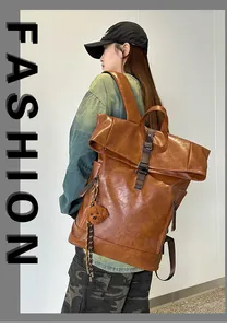Detail view of brown vintage leather backpack featuring buckle straps and bear charm