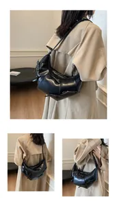 Vue détaillée du sac demi-lune noir avec nœuds décoratifs et fermeture éclair
