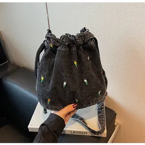 Détails du sac seau en denim gris avec broderies tulipes et fermeture à cordon coulissant