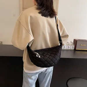 Black quilted crescent crossbody bag with adjustable strap and white rope zipper puller