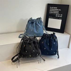Trois sacs seaux en toile brodée avec fermeture à cordon en bleu et noir élégant