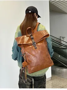 Detail of vintage brown leather backpack featuring a plush bear charm and metal buckles