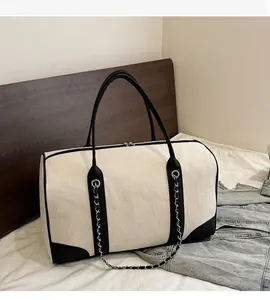 Detail of canvas tote bag showing top zipper closure and black contrast trim handle