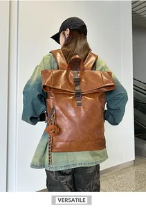 Detailed view of brown PU leather roll-top backpack with metal buckle and side pockets