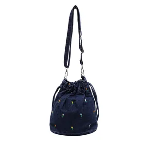 Sac seau en denim bleu avec broderies florales colorées et bandoulière réglable