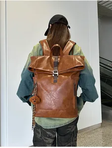 Close-up of vintage brown PU leather texture and flap buckle on waterproof backpack