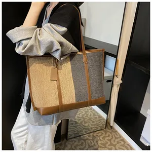 Detail einer großen Kontrast-Tote-Bag mit Canvas-Struktur und Ledergriffen für Damen
