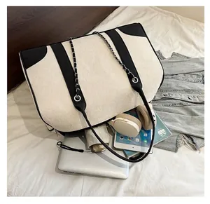 Top view of spacious contrast canvas tote bag filled with a laptop and daily essentials