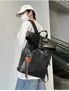 Detail view of large waterproof black PU backpack with roll-top design and brown leather buckle