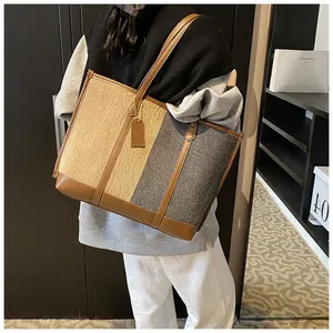 Detailansicht der großen Kontrast-Tote-Bag mit Stroh-Textur und braunem Lederbesatz