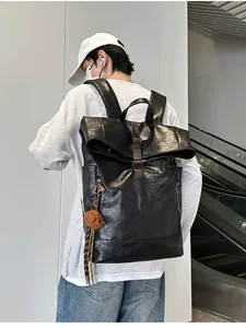 Detail of black waterproof backpack featuring buckle closure and cute bear plush charm
