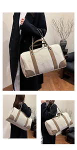 Detail view of canvas tote bag with brown leather trim and metallic chain strap